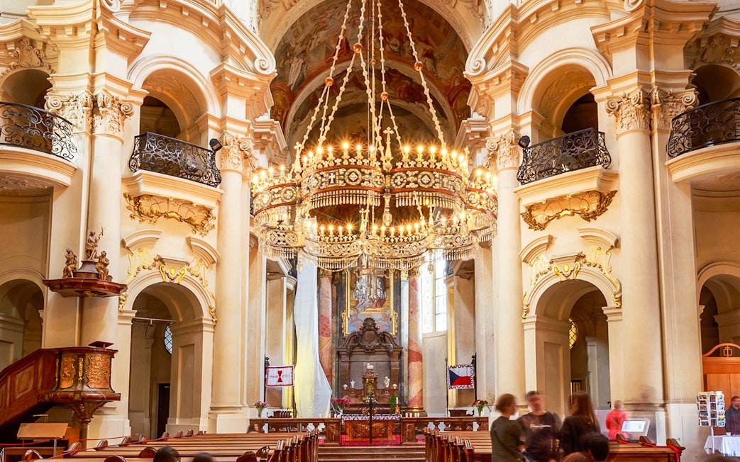 St. Nicholas Church interior with ornate chandelier, Prague classical concert setting.