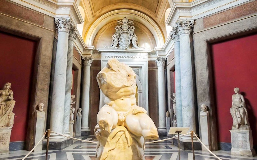 Vatican Museums sculpture hall with ancient statues and marble columns.