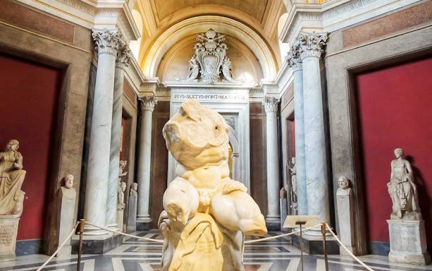 Vatican Museums sculpture hall with ancient statues and marble columns.