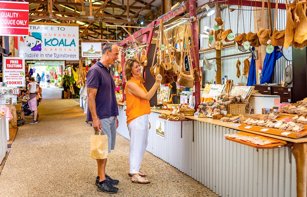 Couple shopping for local crafts at Kuranda markets on a tour from Cairns.