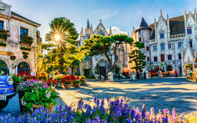 French Village square with medieval architecture and colorful flowers, Sun World Ba Na Hills, Da Nang.