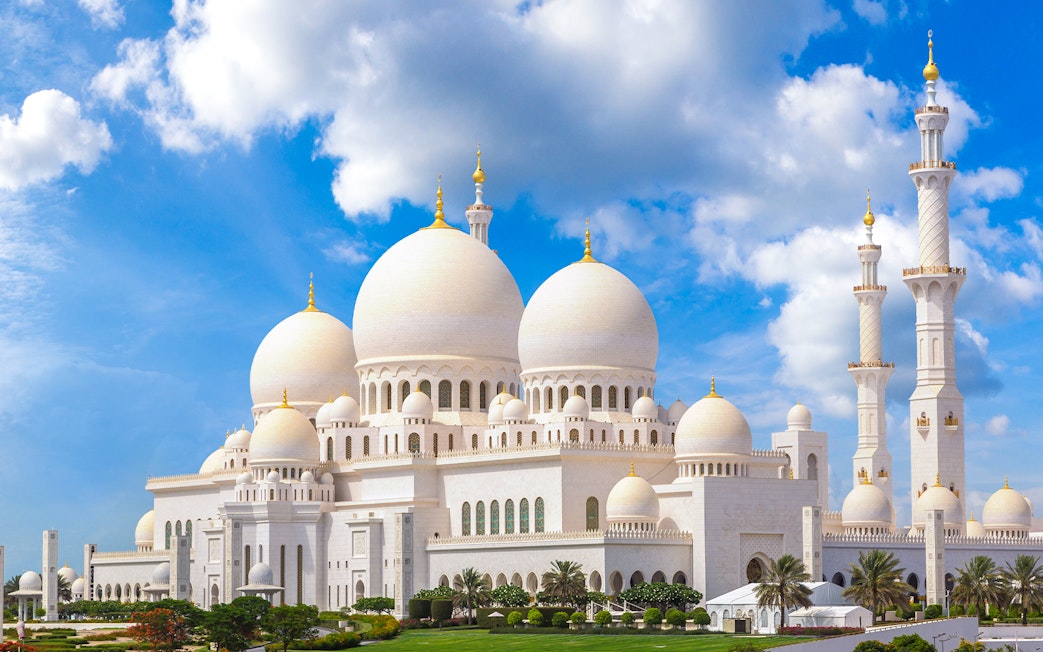 Sheikh Zayed Grand Mosque in Abu Dhabi under a blue sky.