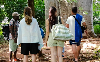 Tourists exploring a forest trail on Funzi Island during a full-day excursion from Diani Beach.