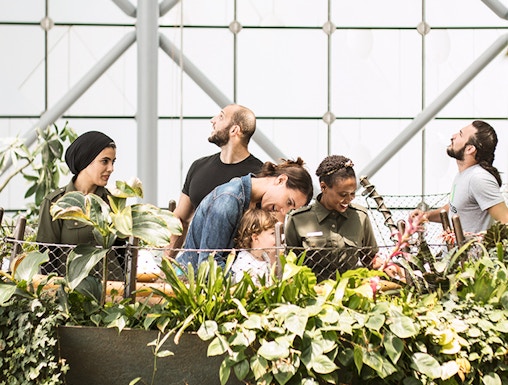 Visitors exploring lush greenery at The Green Planet indoor rainforest.