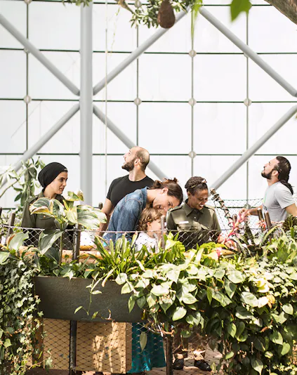 Visitors exploring lush greenery at The Green Planet indoor rainforest.