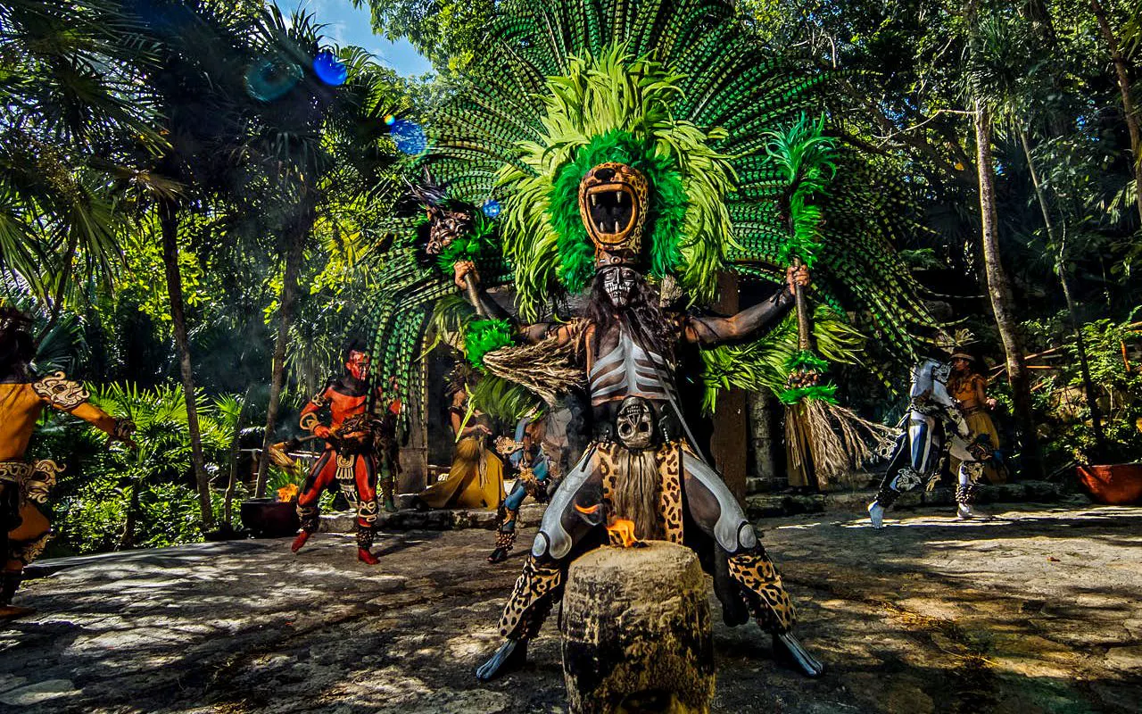 Traditional Mayan performance at Xcaret Park with dancers in vibrant costumes.
