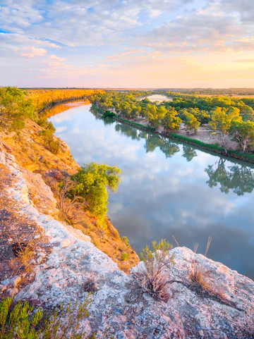 Murray River view with cliffs and trees at sunset, Australia.