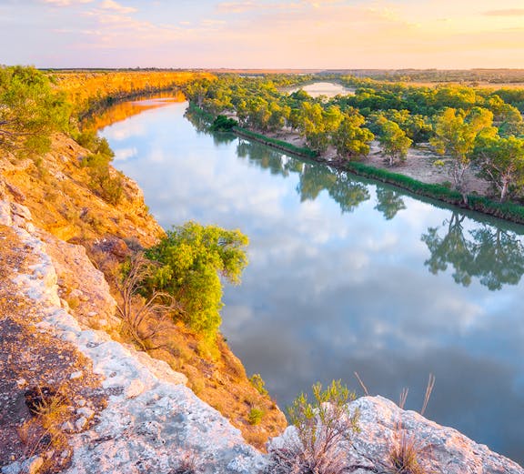 Murray River view with cliffs and trees at sunset, Australia.