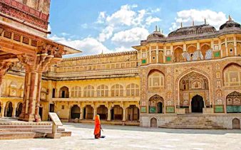 Amber Fort courtyard in Jaipur with intricate architecture and a person in traditional attire.