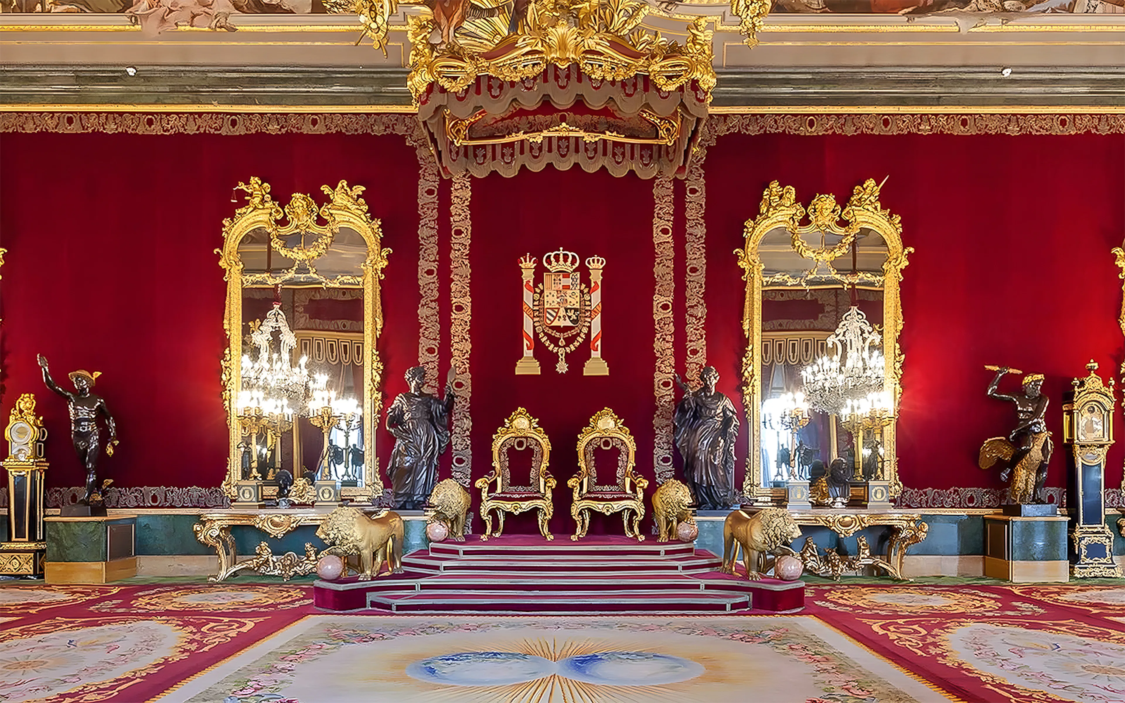 Royal Palace of Madrid throne room with ornate red and gold decor.
