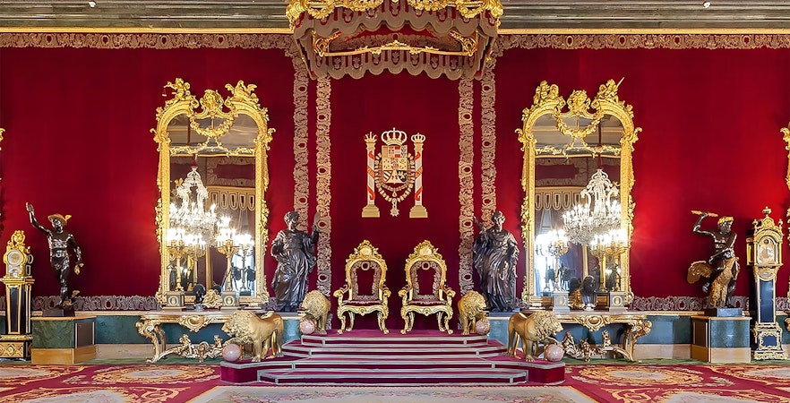 Royal Palace of Madrid throne room with ornate red and gold decor.