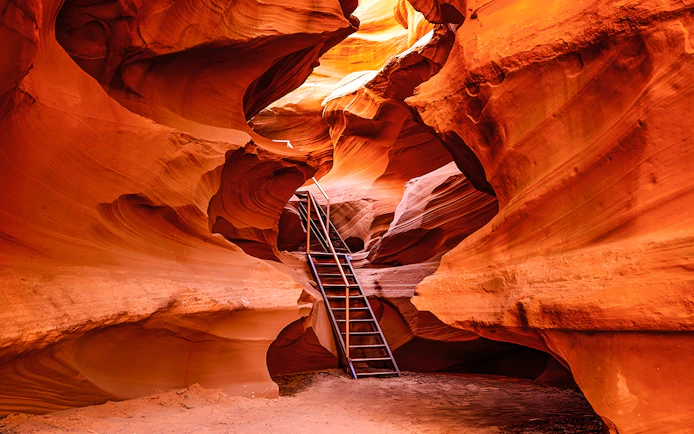 Ladder leading through narrow sandstone formations in Waterhole Canyon.