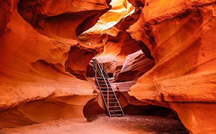 Ladder leading through narrow sandstone formations in Waterhole Canyon.