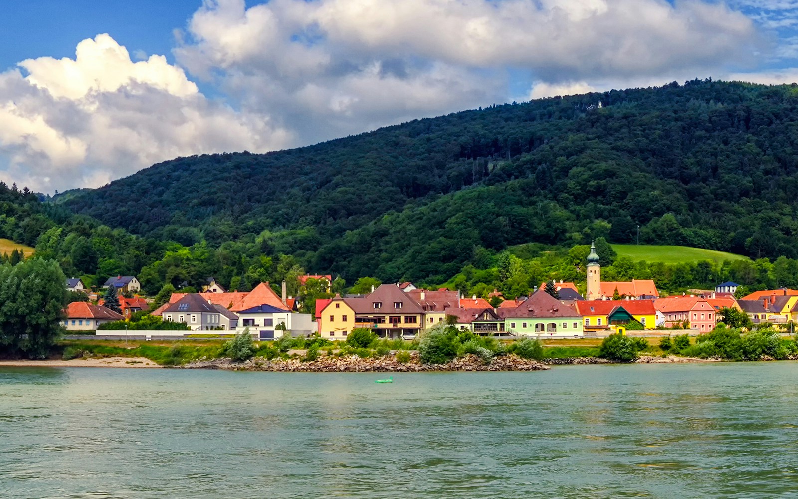 Village of Willendorf along the Danube River in Wachau Valley, Austria, with lush hills in the background.