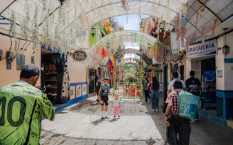 Street scene in Guatapé with colorful buildings and hanging flowers.