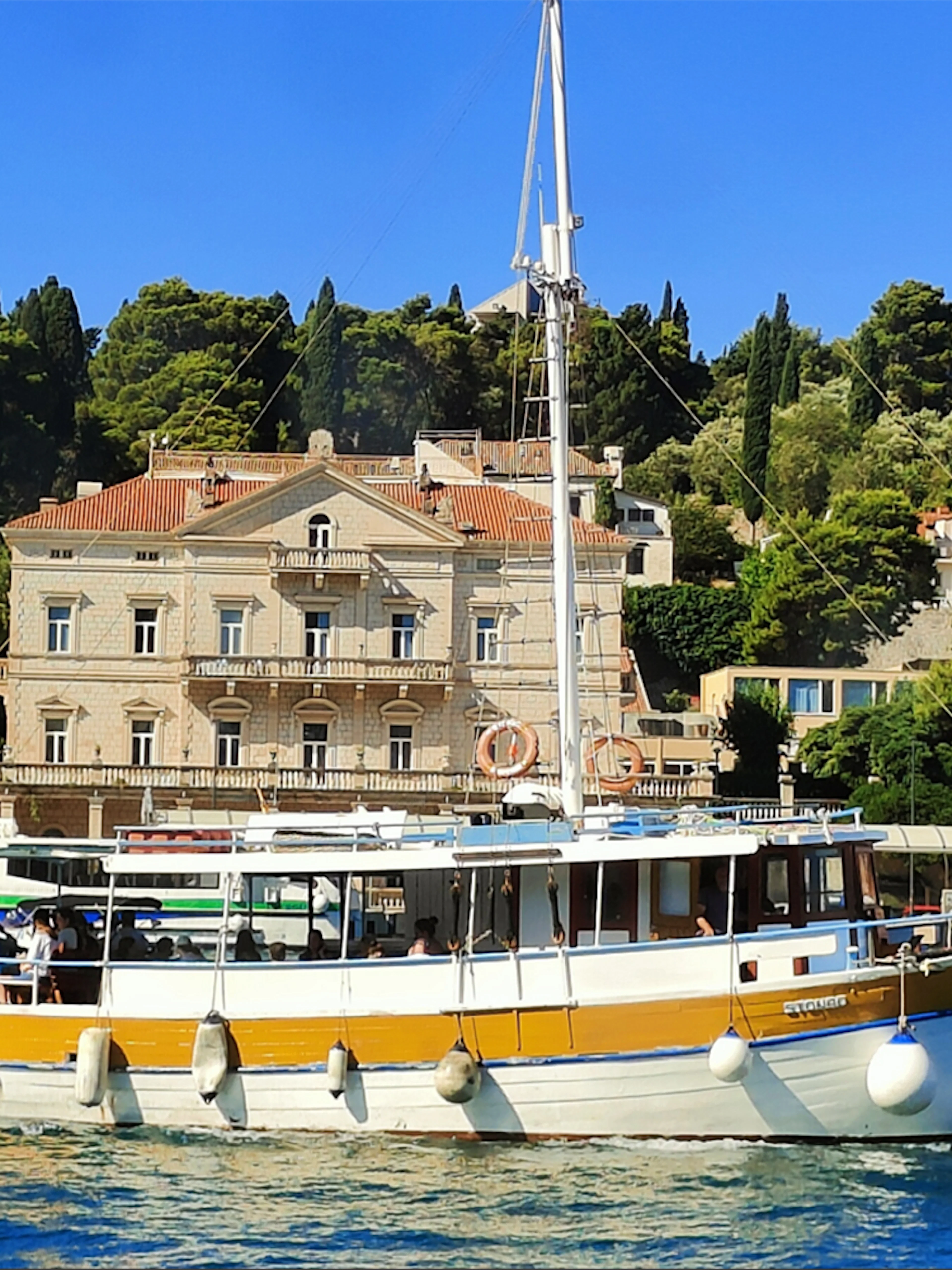 Boat cruising near historic buildings on Elafiti Islands, Dubrovnik, Croatia.