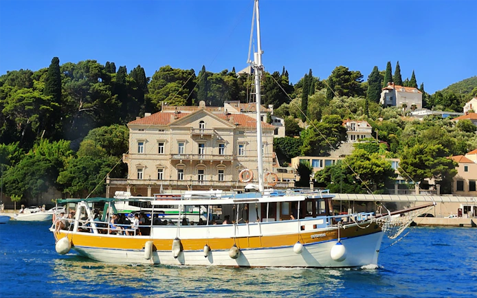 Boat cruising near historic buildings on Elafiti Islands, Dubrovnik, Croatia.