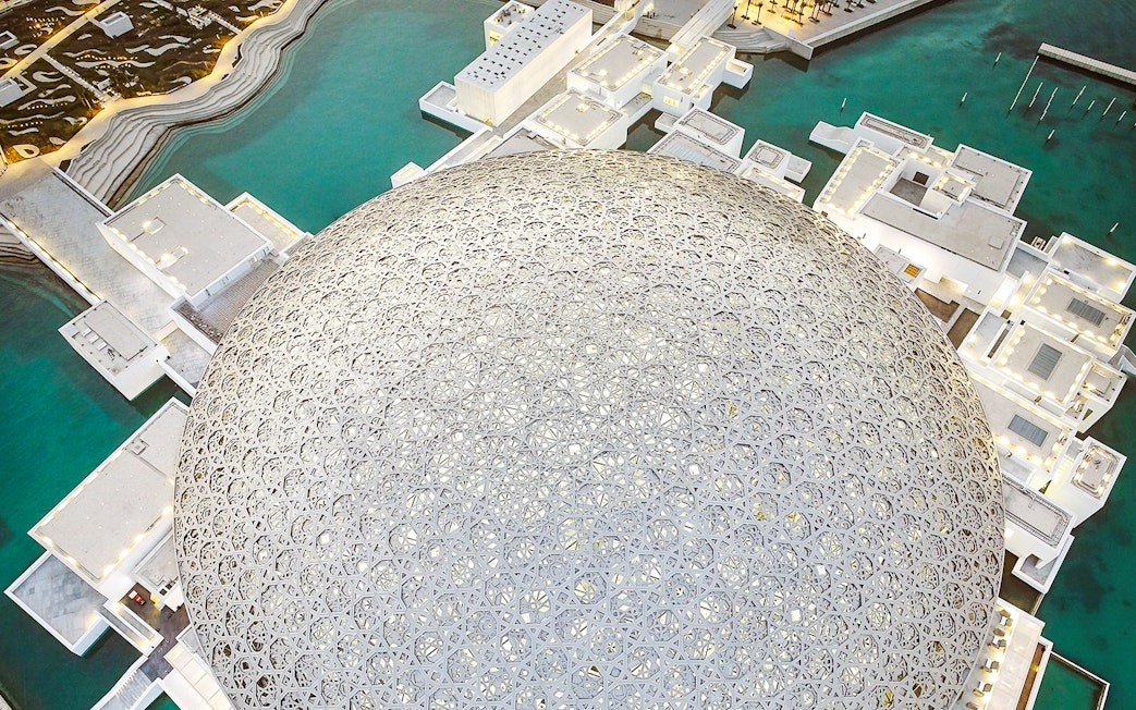 Louvre Museum Abu Dhabi dome with surrounding water and architecture.
