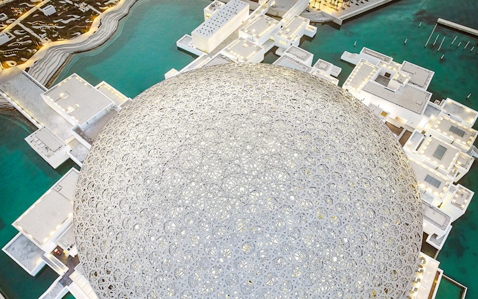 Louvre Museum Abu Dhabi dome with surrounding water and architecture.