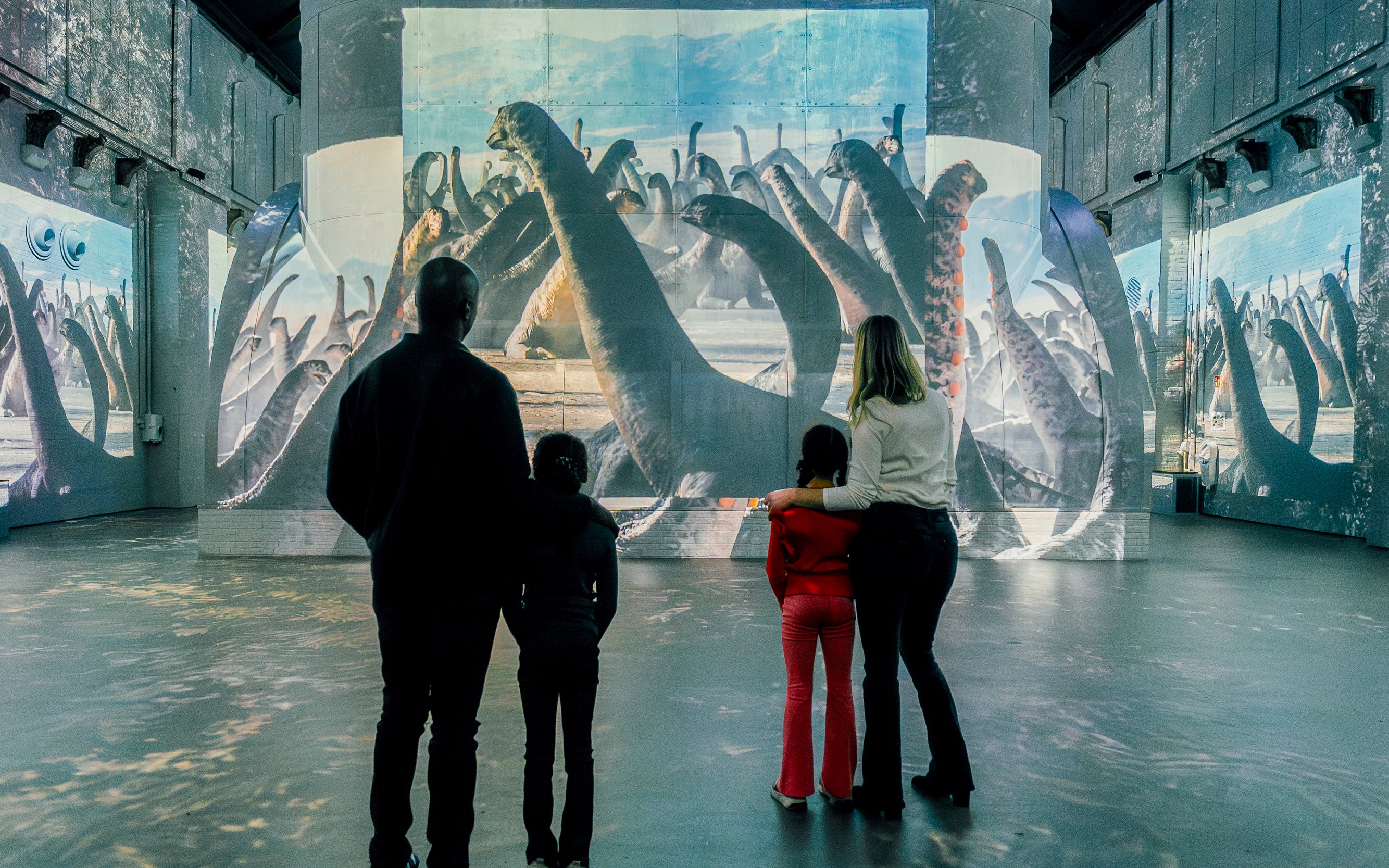 Visitors viewing dinosaur projections at Prehistoric Planet: Dinosaurs – The Immersive Experience.