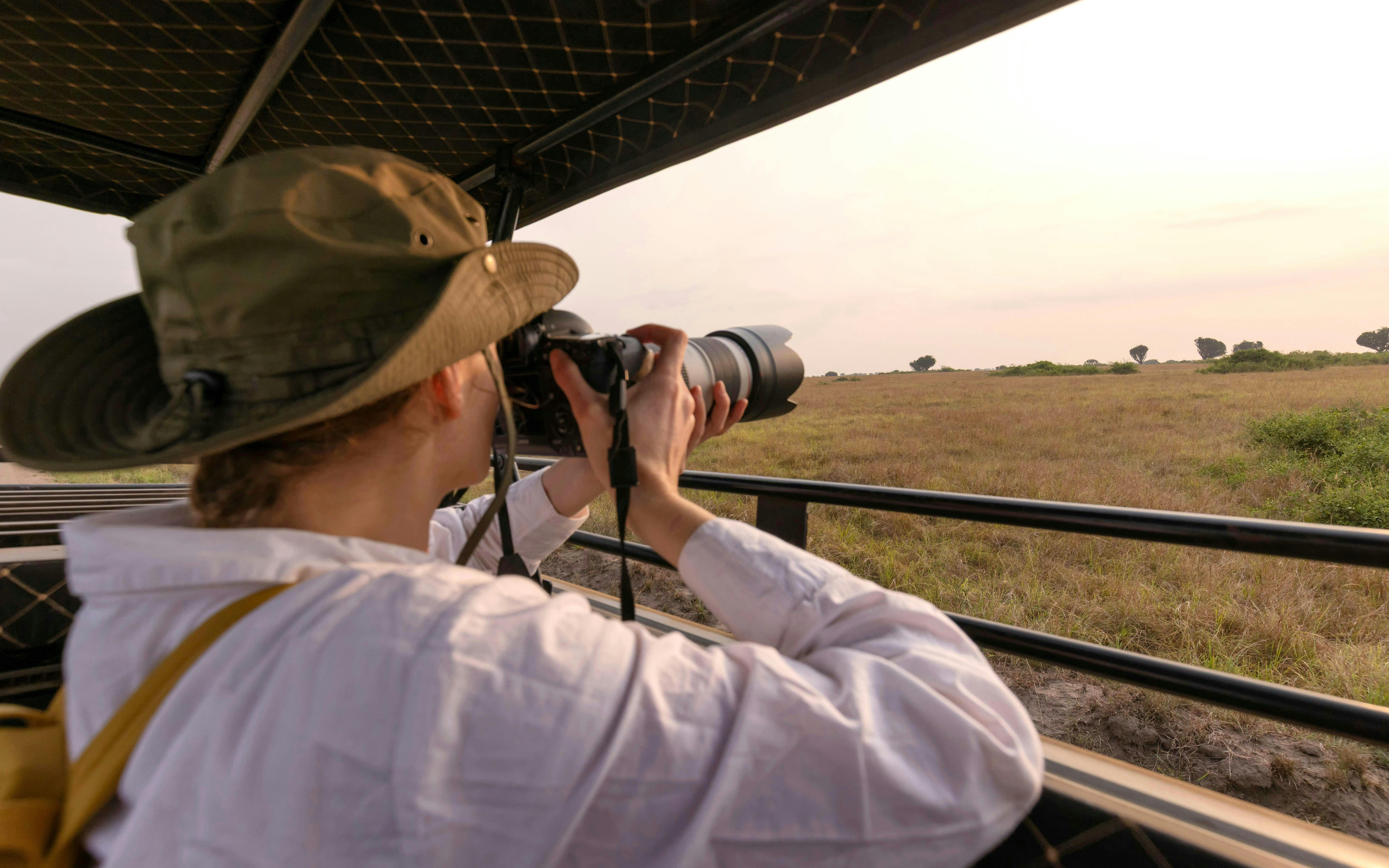 Tourist photographing wildlife on a safari tour in Kenya.