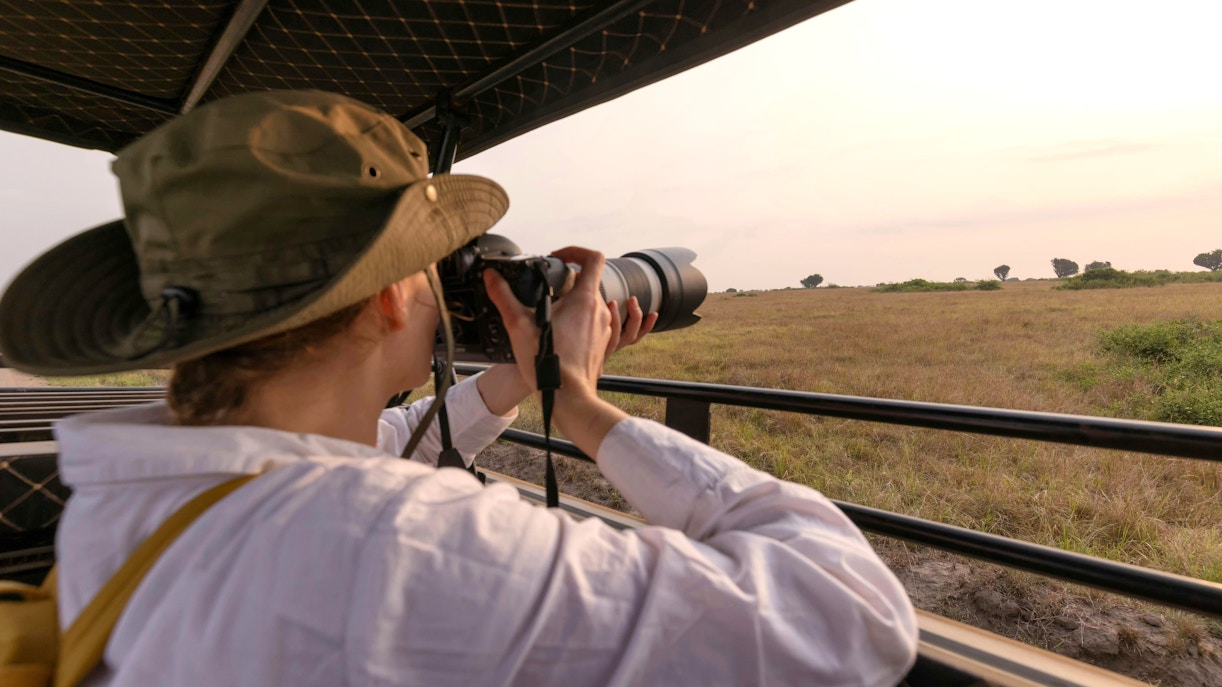 Tourist photographing wildlife on a safari tour in Kenya.