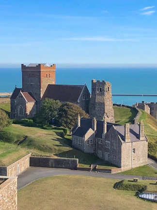 Medieval castle and buildings overlooking the sea on a London to Canterbury tour.