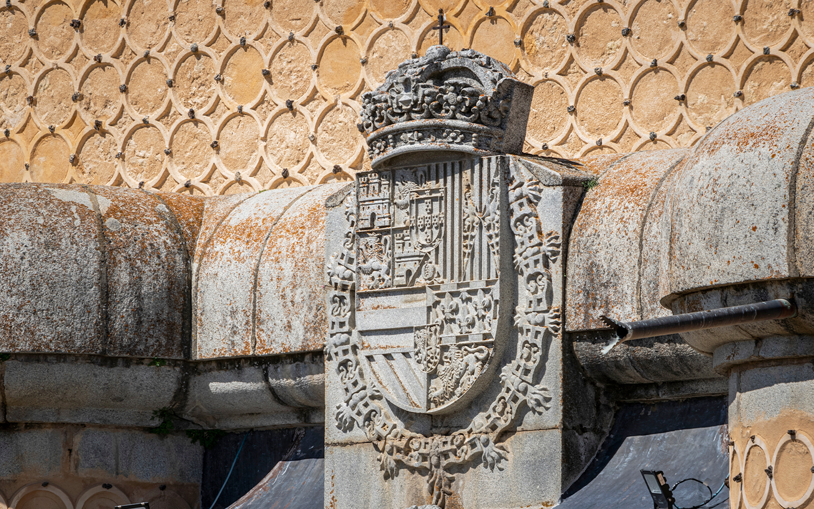Royal coat of arms on stone wall at Alcázar of Segovia, Spain.