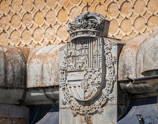 Royal coat of arms on stone wall at Alcázar of Segovia, Spain.