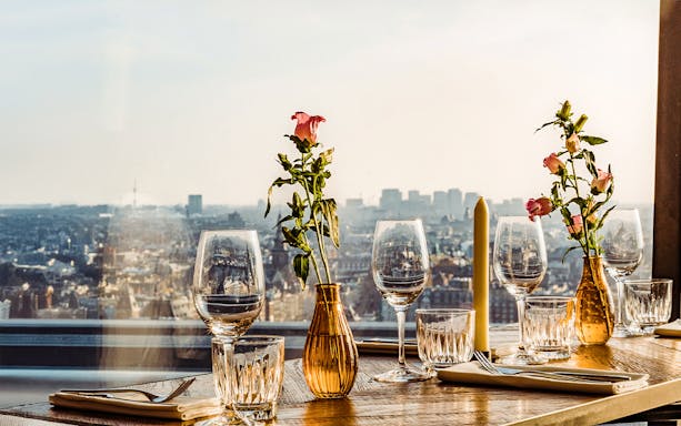 A'DAM Lookout observation deck view in Amsterdam with two drinks on table.