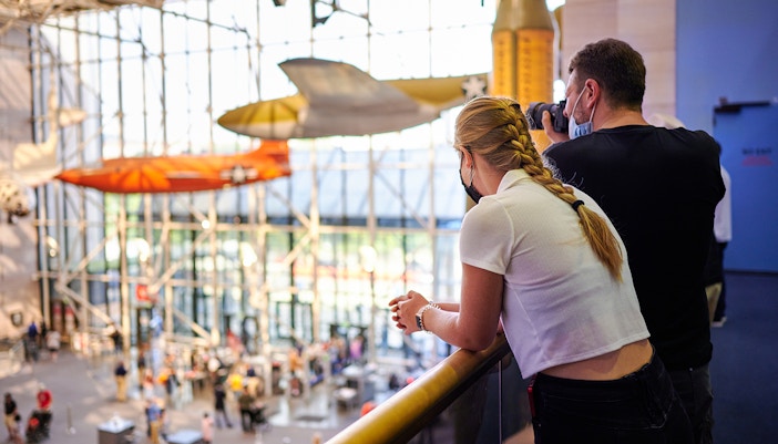 Visitors observing aircraft displays at the Smithsonian National Air and Space Museum.