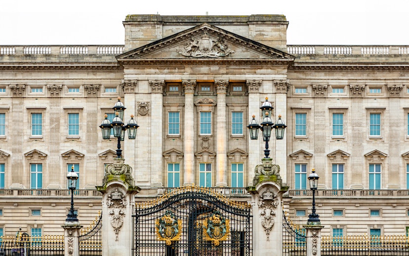 Buckingham Palace facade with ornate gates and lampposts, London.