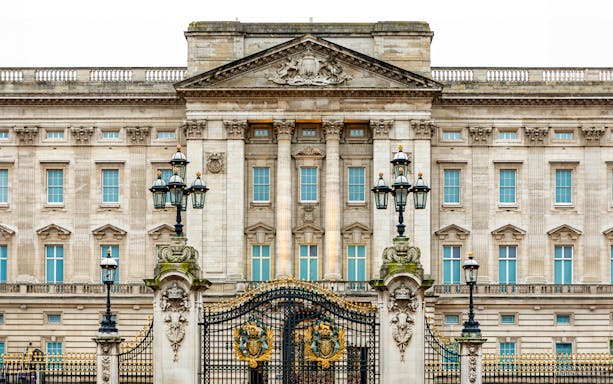Buckingham Palace facade with ornate gates and lampposts, London.
