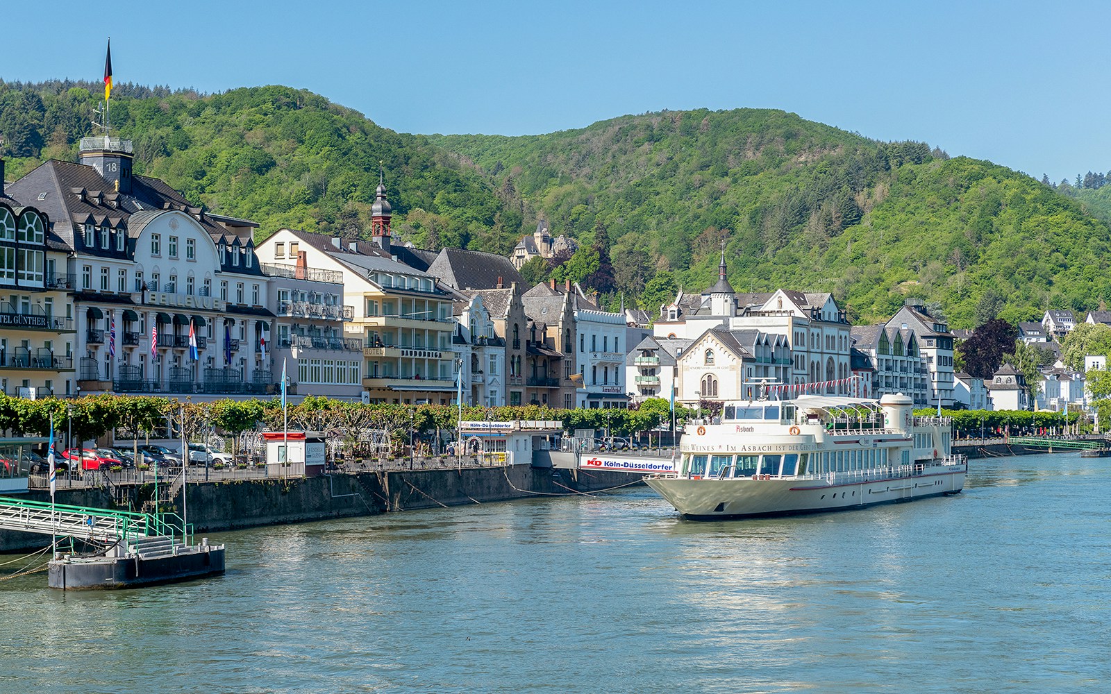 Ein Ausflugsschiff fährt auf einem Fluss an der Koblenzer Altstadt vorbei