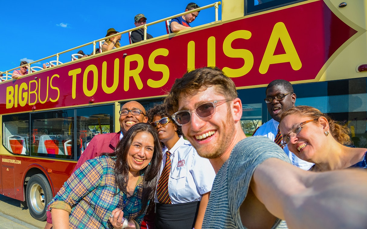 Group taking a selfie in front of a Big Bus Tours vehicle during Washington DC Hop-On-Hop-Off Tour.