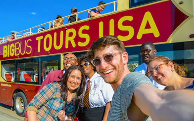 Group taking a selfie in front of a Big Bus Tours vehicle during Washington DC Hop-On-Hop-Off Tour.