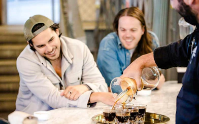 Barista pouring coffee for guests during VIP Morning Market Experience.