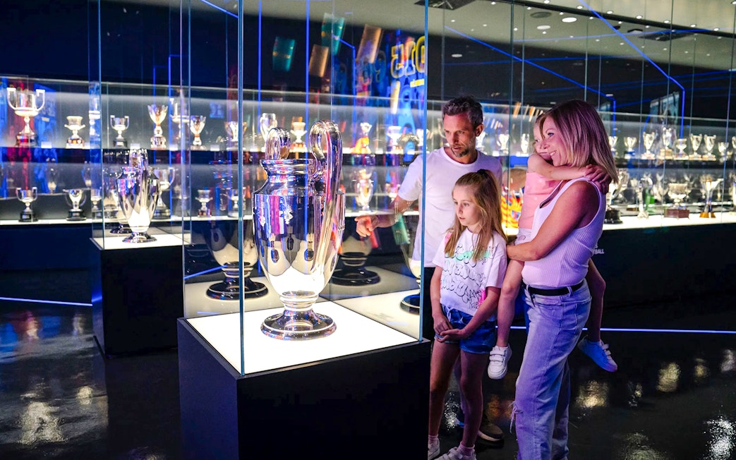 Family exploring trophy displays at Spotify Camp Nou Barça Museum.