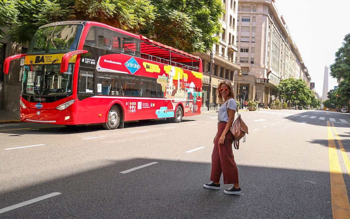 Woman crossing street near Buenos Aires hop-on hop-off bus.