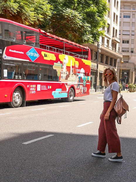 Woman crossing street near Buenos Aires hop-on hop-off bus.