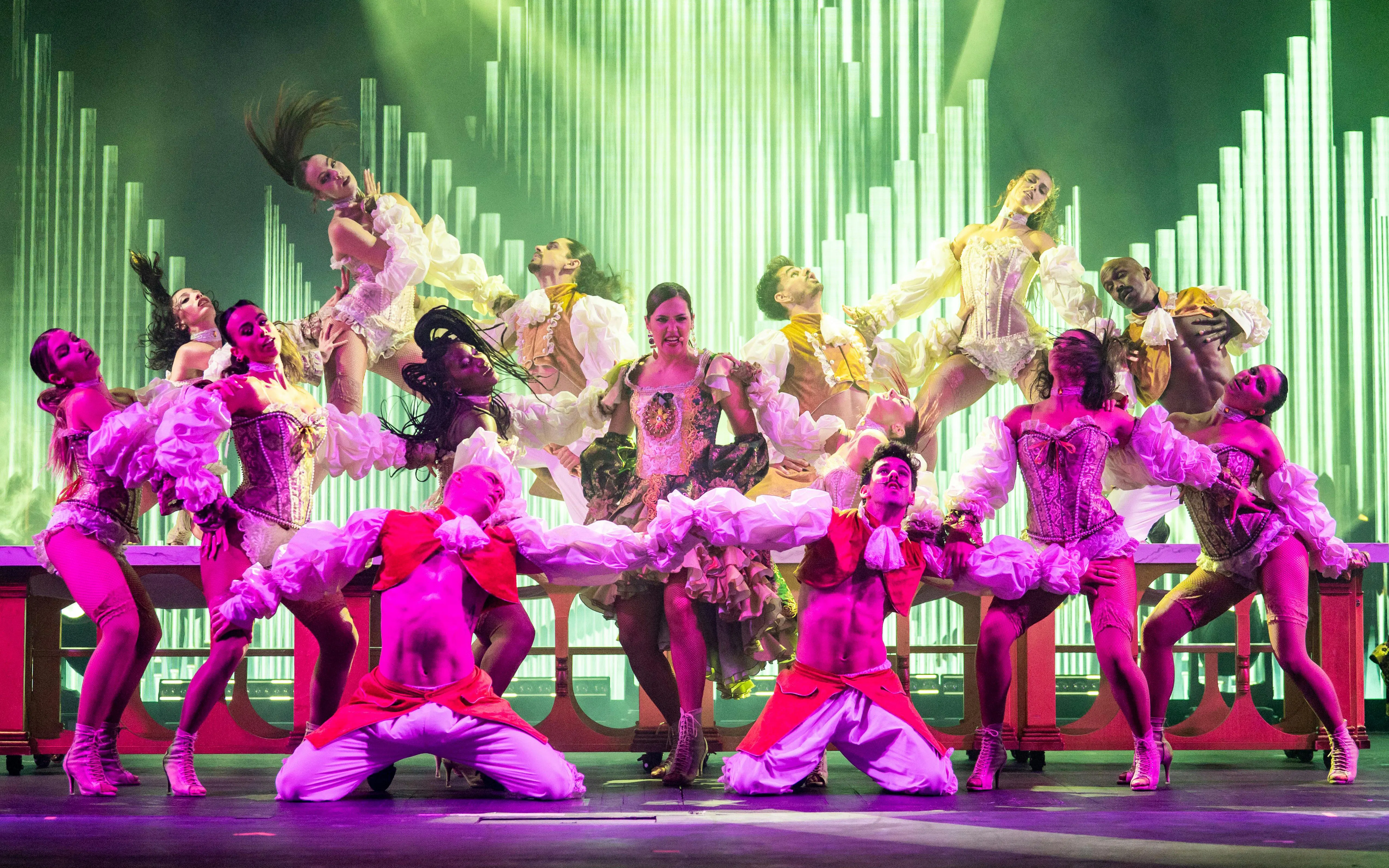 Dancers performing at Sala Scala Gran Canaria with vibrant costumes and dynamic poses.