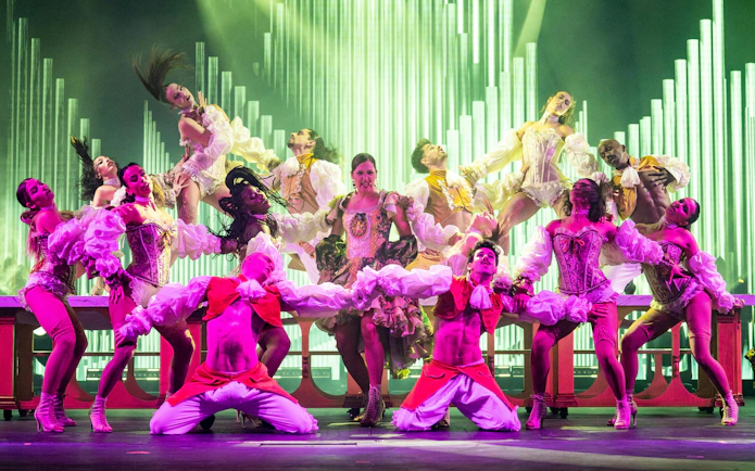 Dancers performing at Sala Scala Gran Canaria with vibrant costumes and dynamic poses.