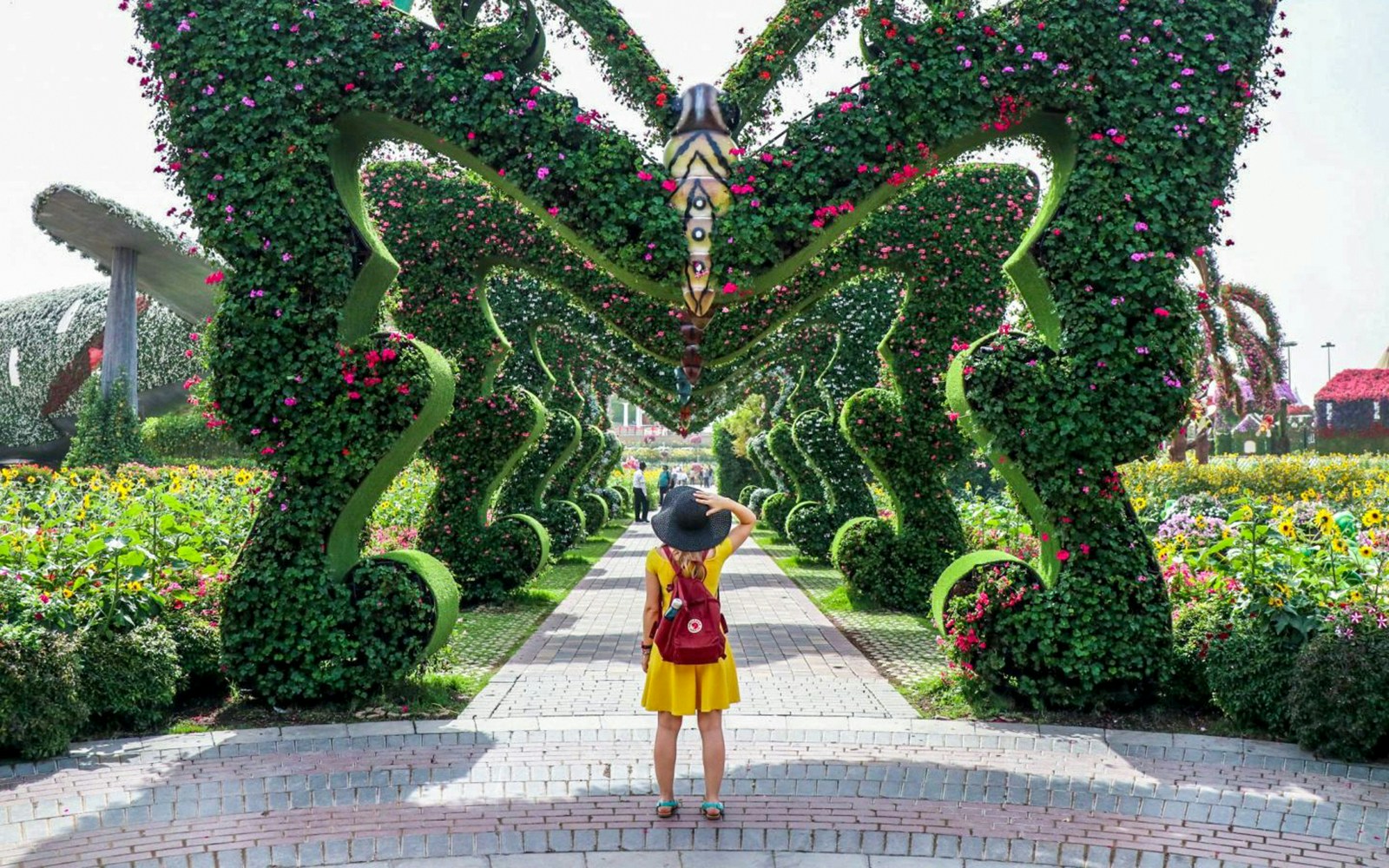 Visitor exploring floral archway at Dubai Miracle Garden.
