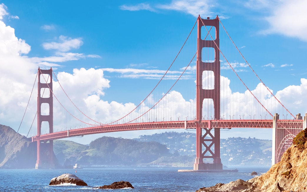 Golden Gate Bridge spanning San Francisco Bay under a clear sky.