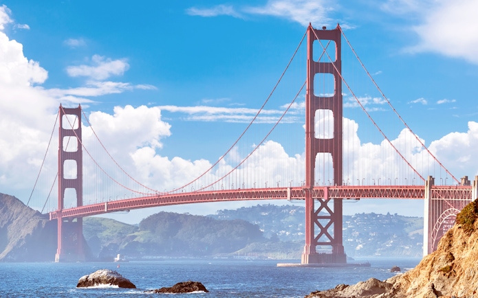 Golden Gate Bridge spanning San Francisco Bay under a clear sky.