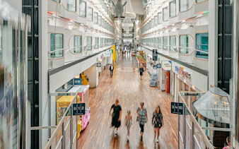 Shopping promenade on overnight ferry to Helsinki with passengers strolling.