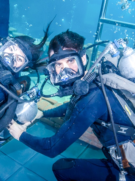 Divers exploring underwater ruins during Sunken City Walk tour.