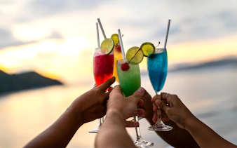 Guests toasting with colorful cocktails on a yacht during a Southern Islands speedboat tour.