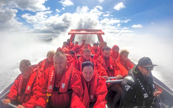 Group enjoying OZ Jet Boating ride in Sydney, water splashing around.