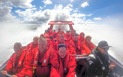 Group enjoying OZ Jet Boating ride in Sydney, water splashing around.
